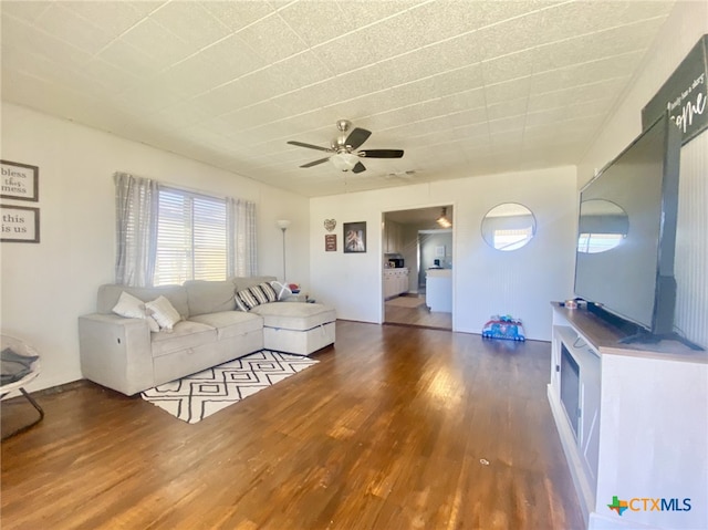 unfurnished living room featuring ceiling fan, a textured ceiling, and dark hardwood / wood-style floors