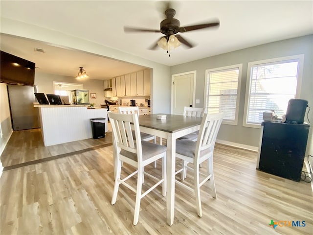 dining room with light wood-type flooring and ceiling fan