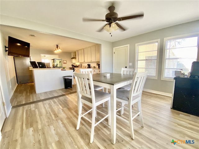 dining area featuring light wood-type flooring and ceiling fan