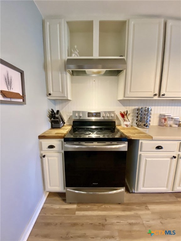 kitchen featuring white cabinets, light hardwood / wood-style flooring, butcher block counters, and electric stove