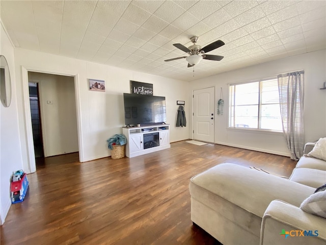 living room featuring dark wood-type flooring and ceiling fan