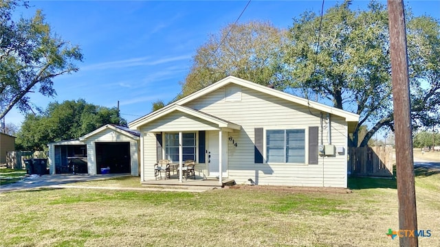 bungalow-style home with covered porch, a front yard, and a garage