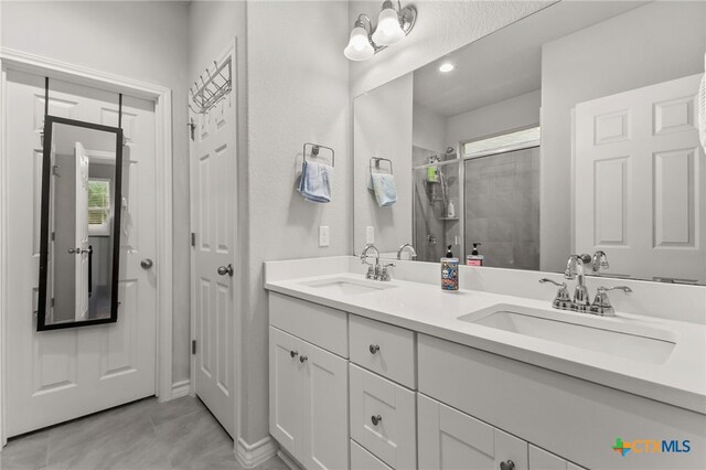135 Mary Max Cir, San Marcos, TX 78666 - full bathroom with a stall shower, double vanity, tile patterned flooring, healthy amount of natural light, and recessed lighting