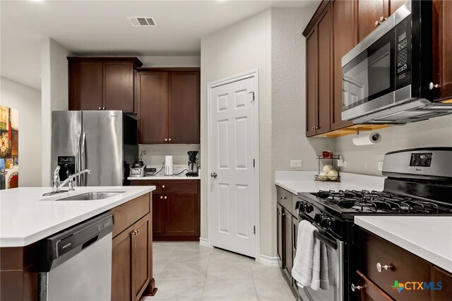 135 Mary Max Cir, San Marcos, TX 78666 - kitchen with appliances with stainless steel finishes, a sink, light countertops, and light tile patterned floors