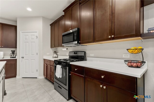 135 Mary Max Cir, San Marcos, TX 78666 - kitchen featuring appliances with stainless steel finishes, light tile patterned flooring, light countertops, dark brown cabinetry, and recessed lighting