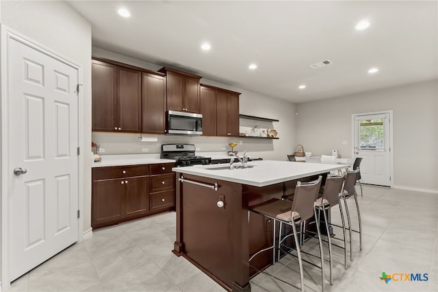 135 Mary Max Cir, San Marcos, TX 78666 - kitchen featuring appliances with stainless steel finishes, an island with sink, light countertops, a breakfast bar area, and a sink