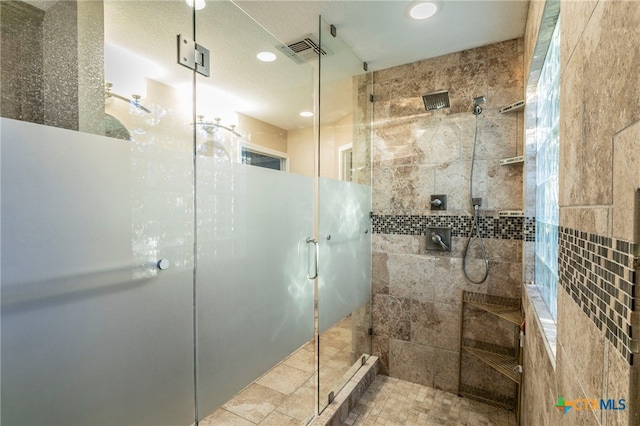 bathroom with a shower with shower door and tile walls