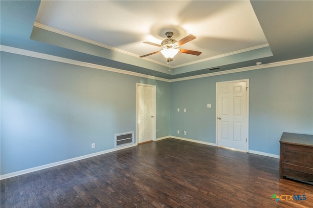 spare room featuring dark hardwood / wood-style floors, crown molding, a tray ceiling, and ceiling fan