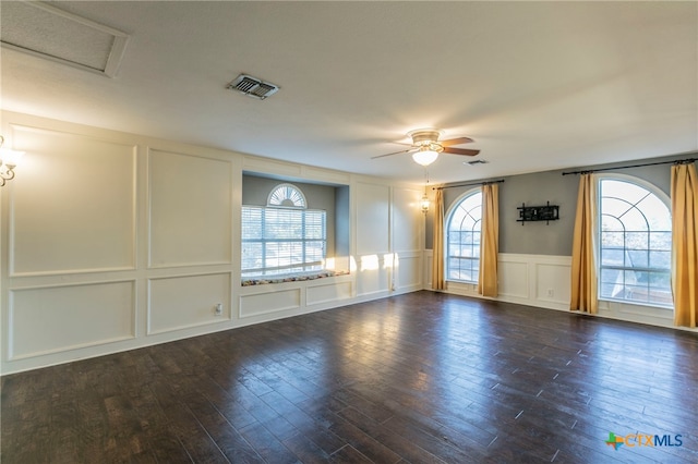 unfurnished room featuring dark wood-type flooring, a wealth of natural light, and ceiling fan