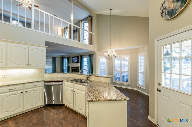 kitchen featuring stainless steel dishwasher, dark hardwood / wood-style floors, pendant lighting, and kitchen peninsula