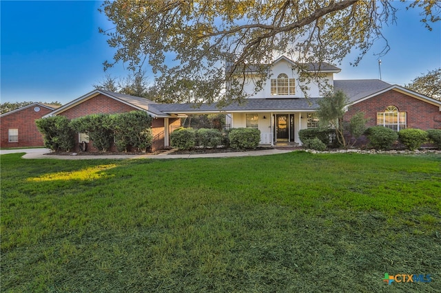 traditional-style house featuring brick siding and a front yard