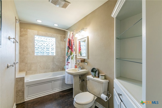 bathroom featuring wood-type flooring, toilet, and shower / tub combo