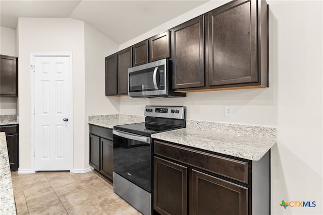 kitchen with dark brown cabinets, light tile patterned flooring, stainless steel appliances, and vaulted ceiling