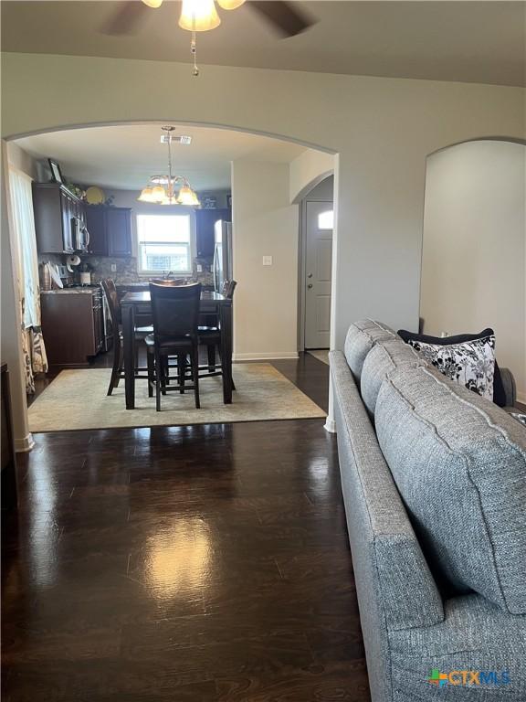 906 2nd St, Cuero, TX 77954 - dining space featuring ceiling fan, arched walkways, and dark wood finished floors