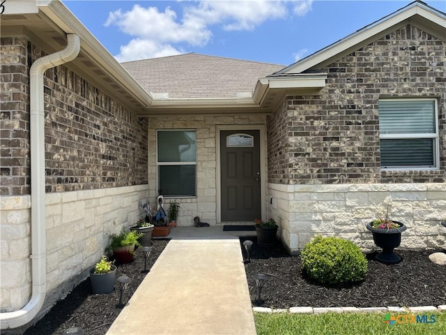 906 2nd St, Cuero, TX 77954 - view of exterior entry with roof with shingles and stone siding
