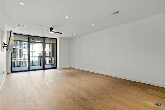 spare room with light hardwood / wood-style flooring, floor to ceiling windows, and ceiling fan