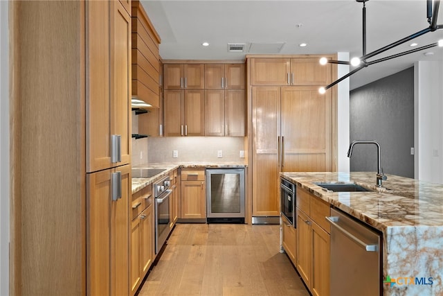 kitchen featuring sink, light hardwood / wood-style flooring, stainless steel appliances, wine cooler, and light stone countertops