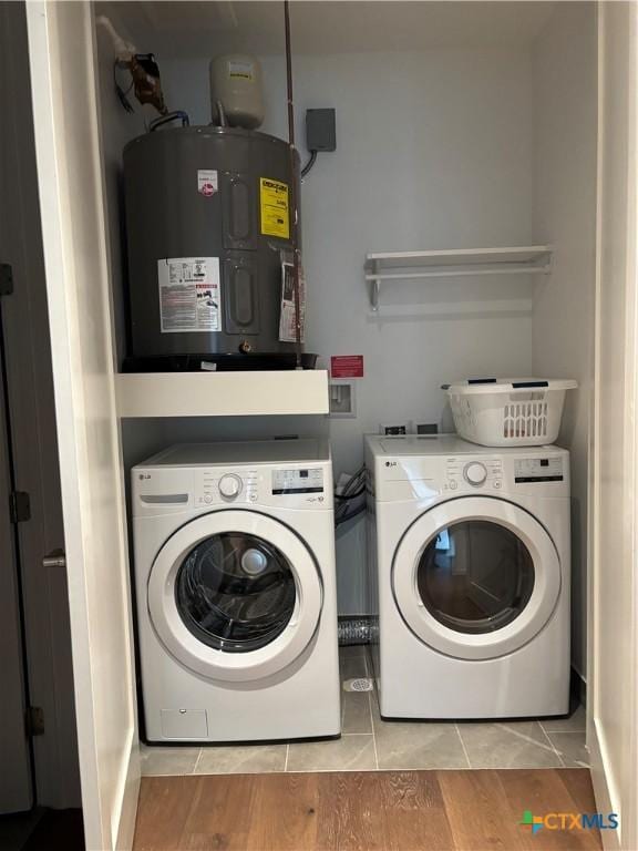 laundry room with washing machine and clothes dryer and water heater