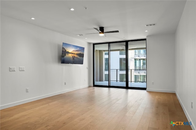 spare room featuring light hardwood / wood-style floors, floor to ceiling windows, and ceiling fan