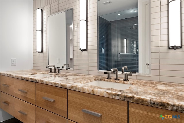 bathroom with vanity, an enclosed shower, and backsplash