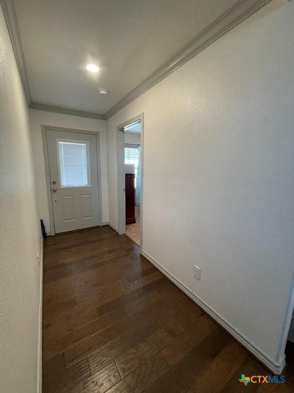 corridor with crown molding, dark wood-style floors, and baseboards