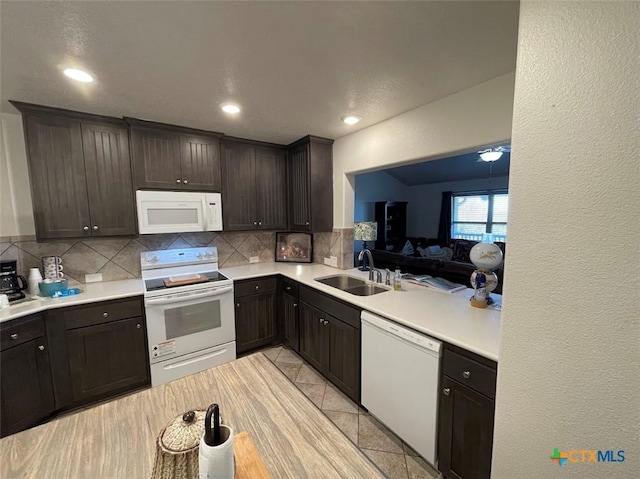 kitchen with white appliances, a sink, decorative backsplash, light countertops, and dark brown cabinets