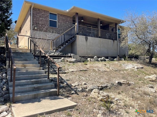 back of property featuring stairway and brick siding