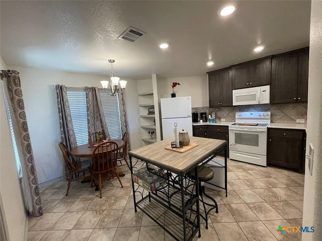 kitchen featuring visible vents, a notable chandelier, backsplash, white appliances, and light countertops