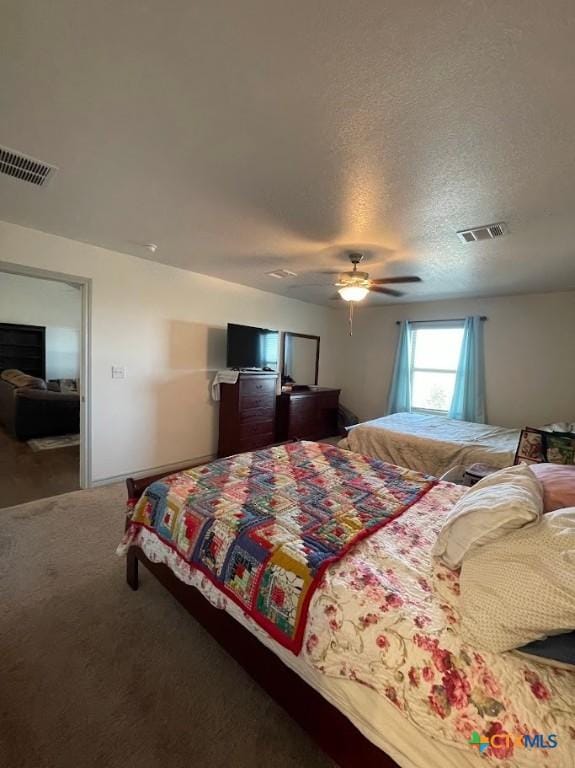 bedroom featuring visible vents, a textured ceiling, ceiling fan, and carpet flooring