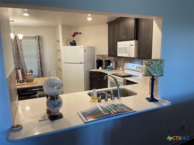 kitchen featuring a sink, white appliances, dark brown cabinetry, light countertops, and decorative backsplash