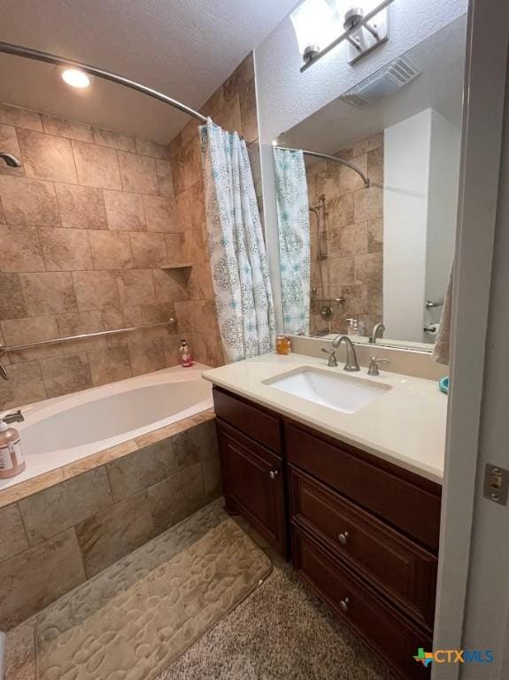 full bath with vanity, visible vents, and tiled shower / bath combo