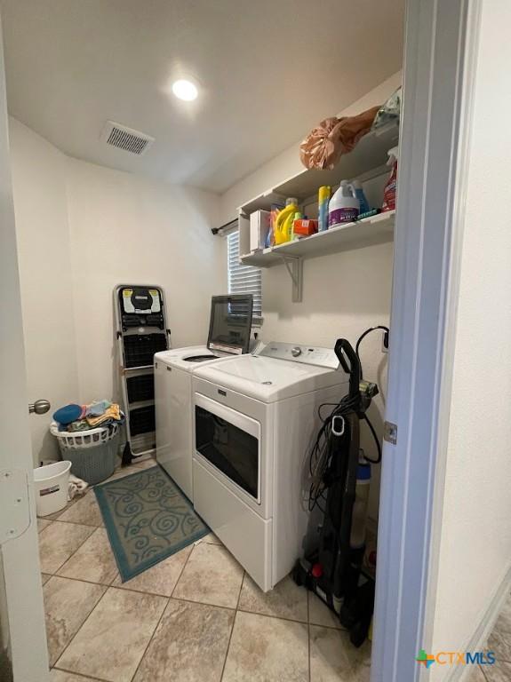 washroom with light tile patterned floors, visible vents, laundry area, and separate washer and dryer