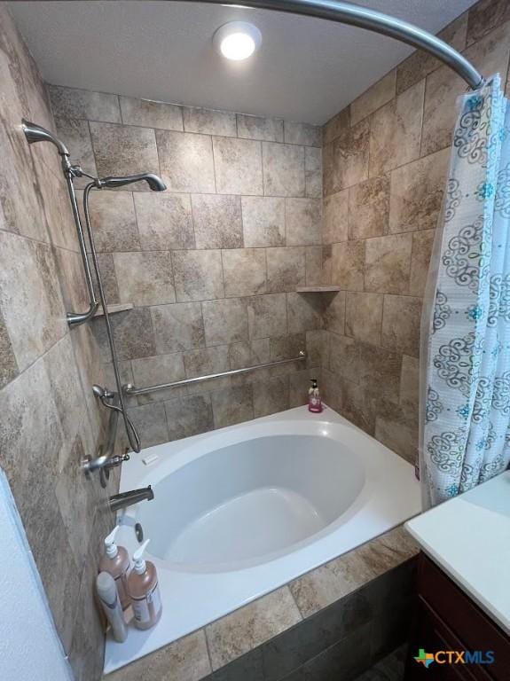 bathroom featuring vanity and tiled shower / bath