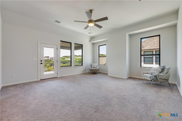 carpeted spare room featuring plenty of natural light and ceiling fan