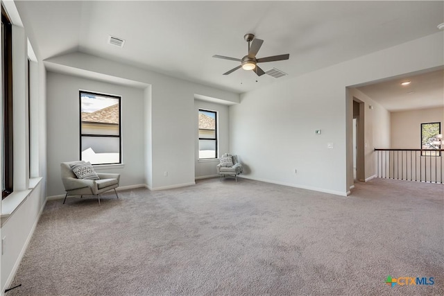 carpeted empty room featuring ceiling fan, a healthy amount of sunlight, and lofted ceiling