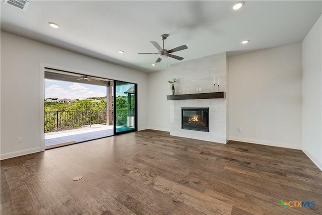 unfurnished living room with a fireplace, dark hardwood / wood-style floors, and ceiling fan