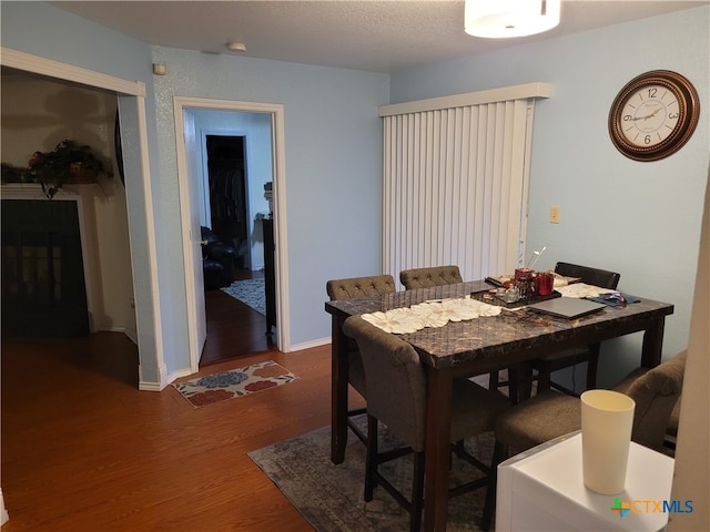 dining space with a textured ceiling and dark hardwood / wood-style flooring