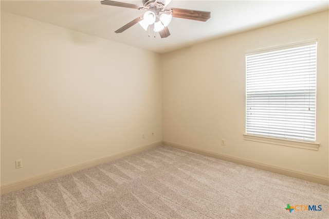 carpeted empty room with a wealth of natural light and ceiling fan