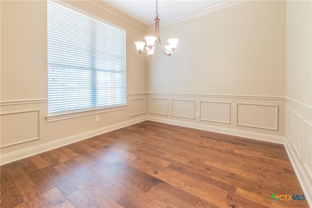 empty room with dark hardwood / wood-style flooring, a notable chandelier, and crown molding