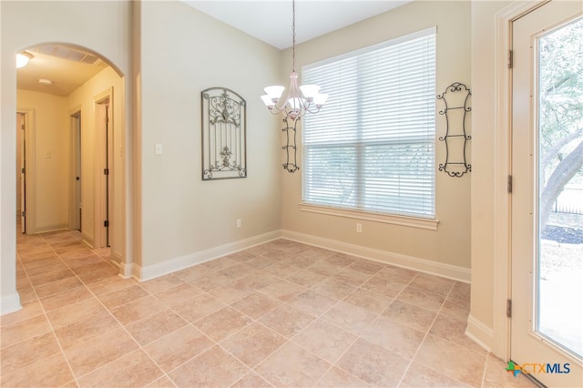 unfurnished dining area featuring a wealth of natural light, an inviting chandelier, and light tile patterned flooring