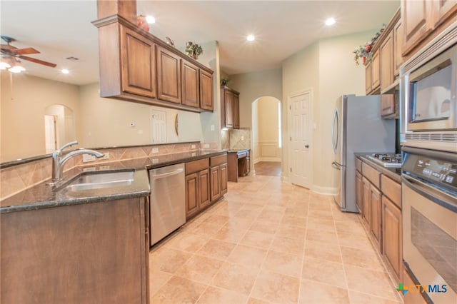 kitchen featuring light tile patterned flooring, appliances with stainless steel finishes, sink, and ceiling fan