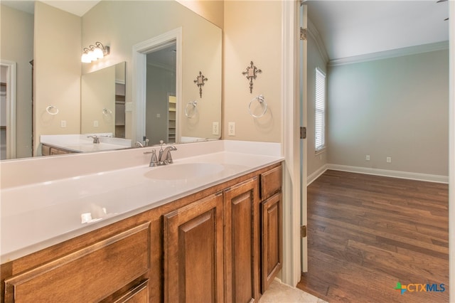 bathroom with wood-type flooring, crown molding, and vanity