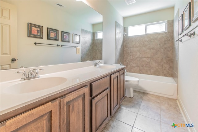 full bathroom with tile patterned flooring, vanity, tiled shower / bath combo, and toilet