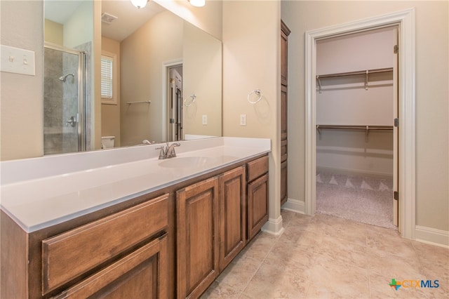 bathroom featuring walk in shower, vanity, and toilet