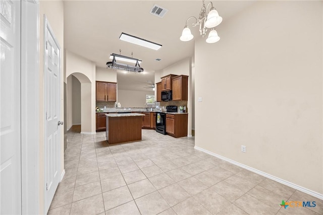 5507 Sulfur Spring Dr, Killeen, TX 76542 - kitchen with black appliances, arched walkways, a center island, light tile patterned flooring, and tasteful backsplash