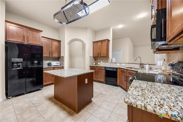 5507 Sulfur Spring Dr, Killeen, TX 76542 - kitchen with black appliances, tasteful backsplash, arched walkways, light tile patterned flooring, and brown cabinetry