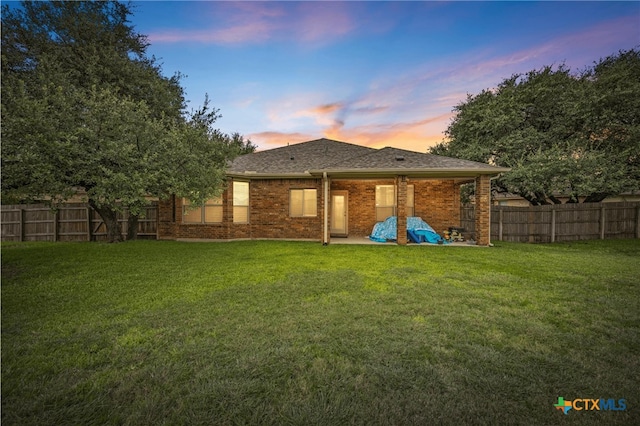 5507 Sulfur Spring Dr, Killeen, TX 76542 - back of property at dusk featuring a fenced backyard, brick siding, and roof with shingles