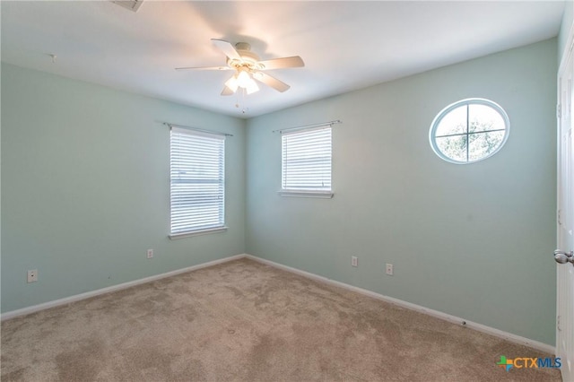 carpeted spare room featuring ceiling fan