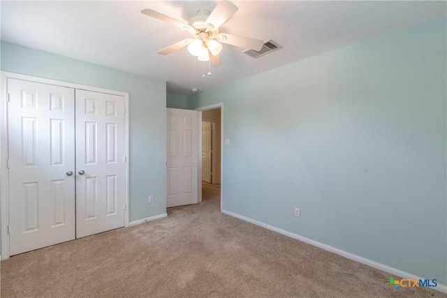 unfurnished bedroom with light colored carpet, ceiling fan, and a closet