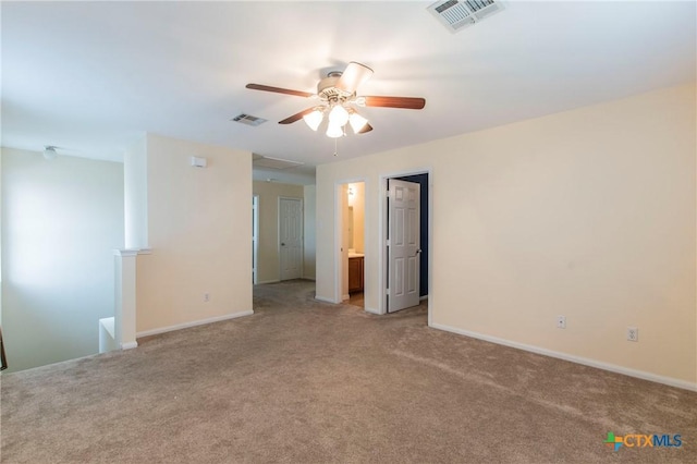 spare room with ceiling fan and light colored carpet